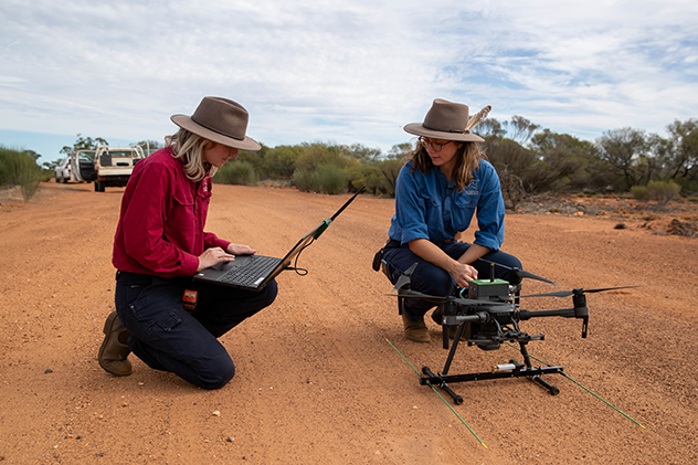 Phoebe Dickins and Georgina Anderson, Australian Wildlife Conservancy Ecologists, prepare to launch a drone.