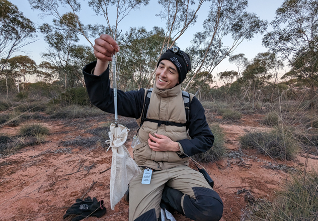 Andrew weighing a small mammal as part of a survey. 